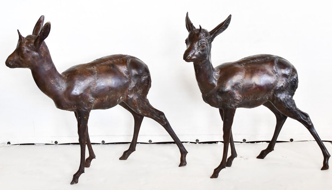 BRONZE PAIR OF HORNED ROE DEER: Both deer are hollow bronze with a painted dark patina, circa early 20th century. Each deer measures approximately 26" H x 25" W x 9.5" D.