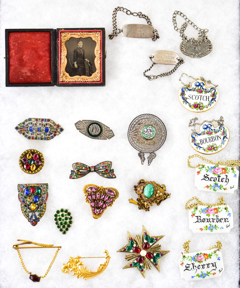 ANTIQUE DECOR ASSORTMENT: TIN-TYPE, DECANTER LABELS, STELRING SILVER, JEWELRY: An assortment of antique decor including a tin-type photograph in an antique photo case, two sterling silver military ID tags, porcelain decanter labels, a metal decanter label, and an assortment of a