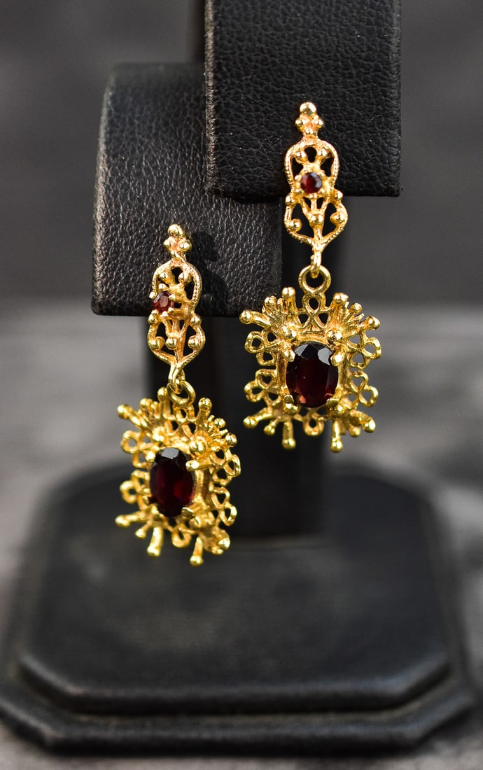 14KT GOLD FILIGREE DROP EARRINGS: Earrings are made of 14kt yellow gold with two ruby colored amethyst gems in each. Each earring measures approx. 1.5" H x 0.5" W x 0.5" D.