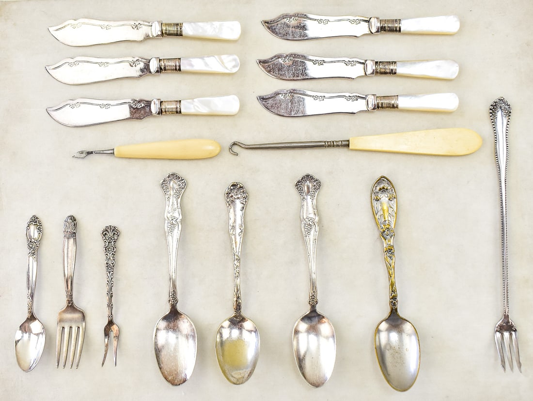 ASSORTMENT OF SILVER-PLATE FLATWARE: An assortment of silver-plate flatware, a celluloid-handled button-hook, and a celluloid-handled nail cleaner. The silver-plated flatware includes a set of six mother of pearl handled butter knives, f