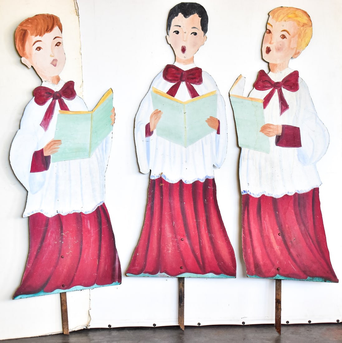 TRIO OF CHOIR BOY CHRSITMAS DISPLAY: All three boys are made of plywood and are each hand painted circa the 1990s. Each boy measures approximately 57.5" H x 16" W x 0.5" D.