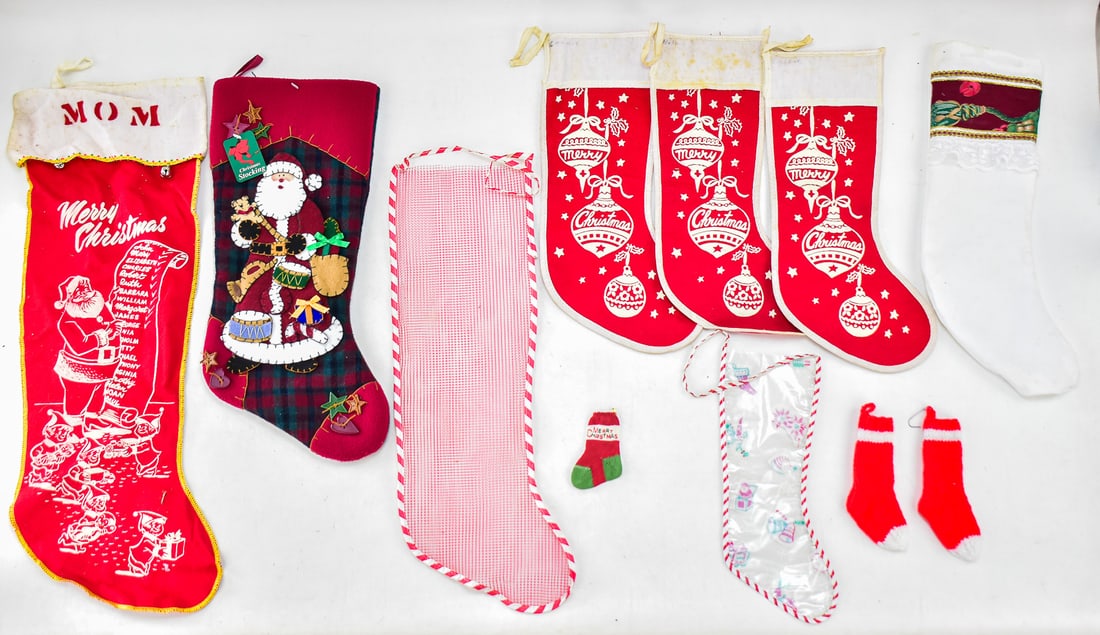 11 CHRISTMAS STOCKINGS: An assortment of eleven Christmas stockings. Eight of the stockings are full size, and three of the stockings are smaller size to be hung on a Christmas tree. The largest stocking measures approximate