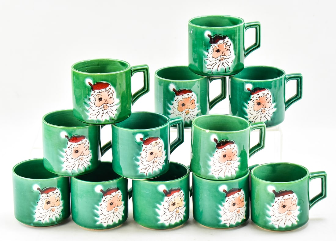 WALES JAPAN WINKING SANTA MUGS SET OF TWELVE: This collection has two sets of six green santa mugs made by Wales in Japan circa mid 20th century. The original box measures approx. 4.5" H x 10.5" W x 7.5" D.