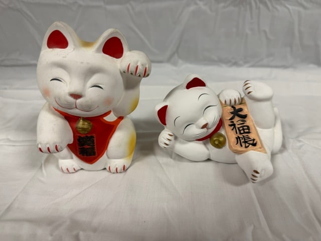 Lucky Maneki-neko cat: Pair of Lucky Maneki-neko waving cat bank. Accordong to Japaese legend, this white Lucky cat brings luck and money with it's waving paw. 5" tall; one is a bank (left) the other figure