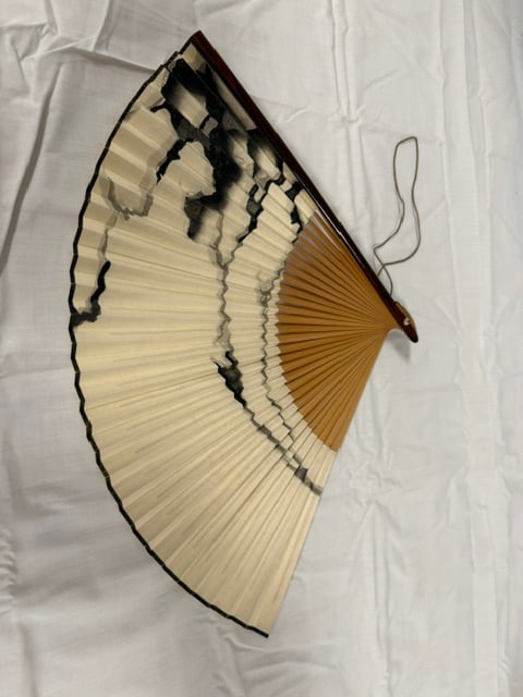 Japanese Fan: Traditional Japanese folding fan or sensu, featuring a bamboo frame and paper fan leaf decorated
