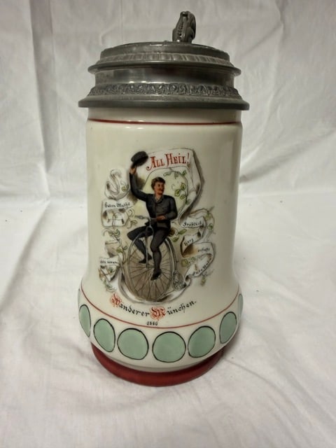 German Beer Stein: Ceramic German beeer stein with pewter lid and hand-painted decoration depicting a man on a barrel; height including handle