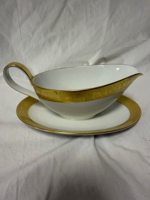 Porcelain Gravy Boat: Porcelain gravy boat with attached uderplate featuring gold rim decoration