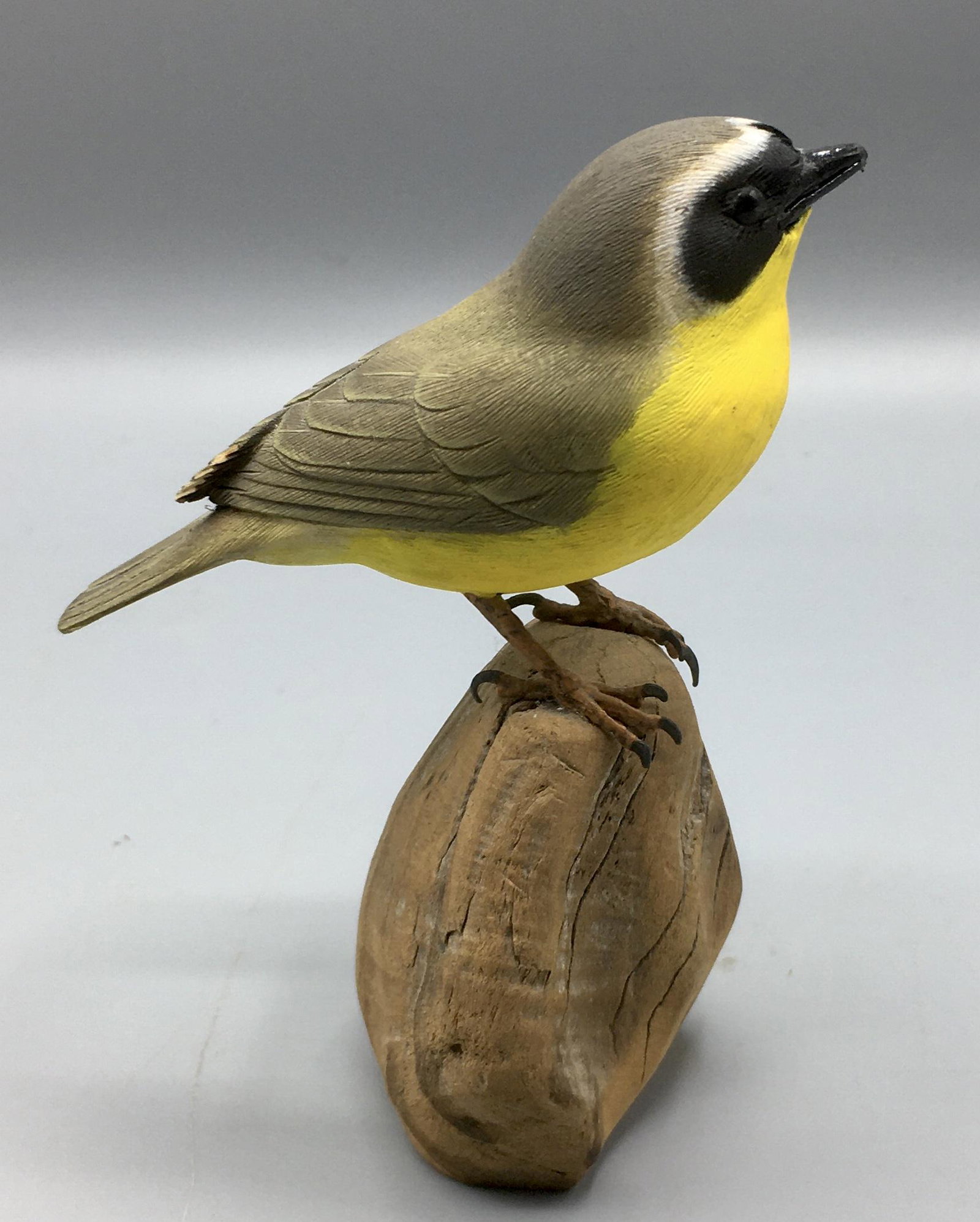 Common Yellowthroat by Randy and Elaine Fisher: A 4 inch Warbler carved by Randy and Elaine Fisher of Dennis,MA, signed on the base. In original paint with wear, there is a rub on one primary feather group and a small chip in a tail feather.
