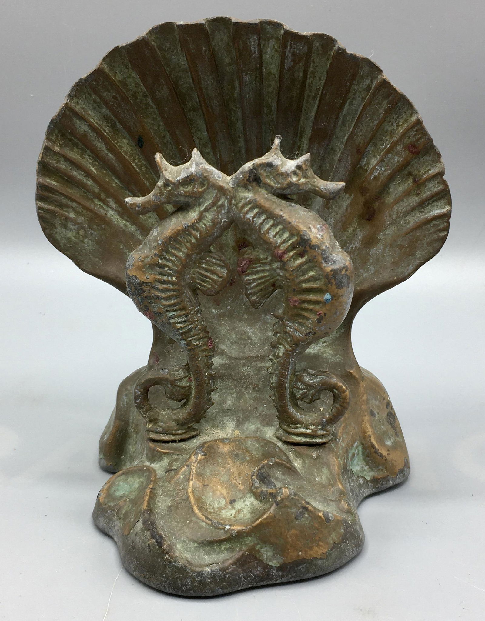 Two Nautical Doorstops: A 7 1/4 inch metal lighthouse doorstop and a 5 inch seahorse and shell metal doorstop. The shell doorstop was made by McClelland Barclay, who was a noted artist and an active duty American Naval Offic