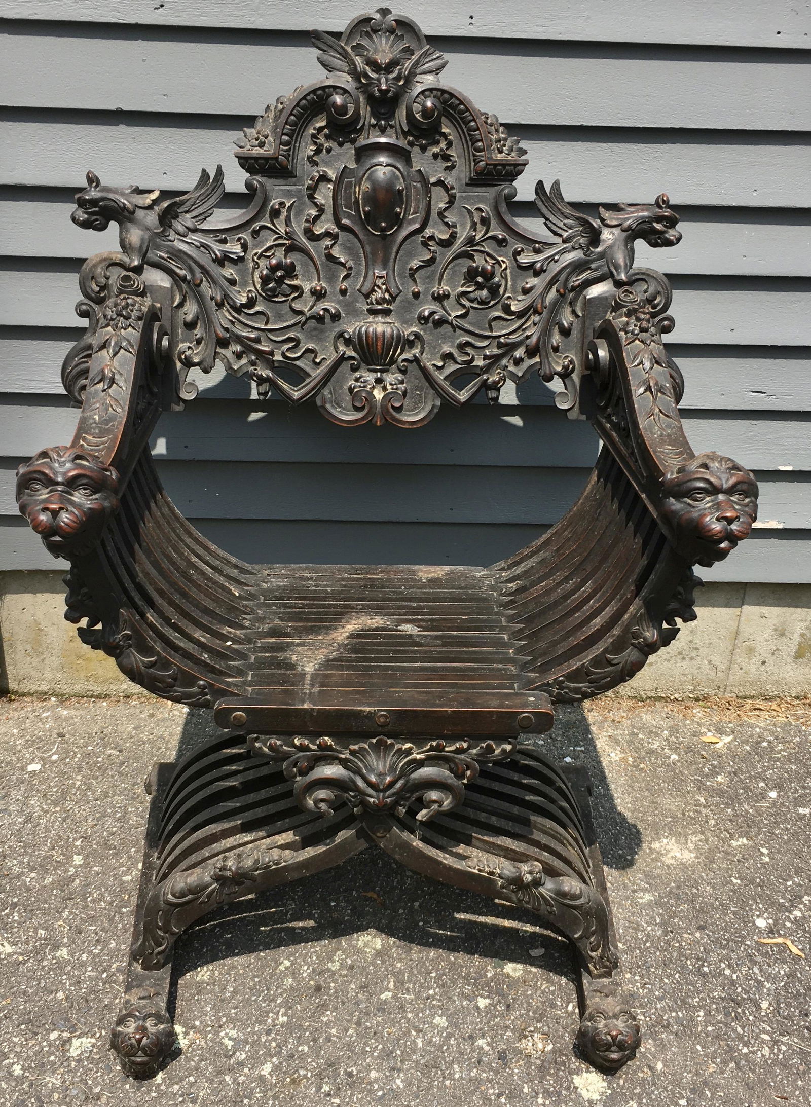 Italian Walnut Savonarola Chair with Lions and Griffins: An incredibly carved chair measuring 44 by 30 1/2 by 26 inches. A Baroque style hand carved museum quality chair with griffin carvings on its wings and lion or griffin heads at the end of its arms and