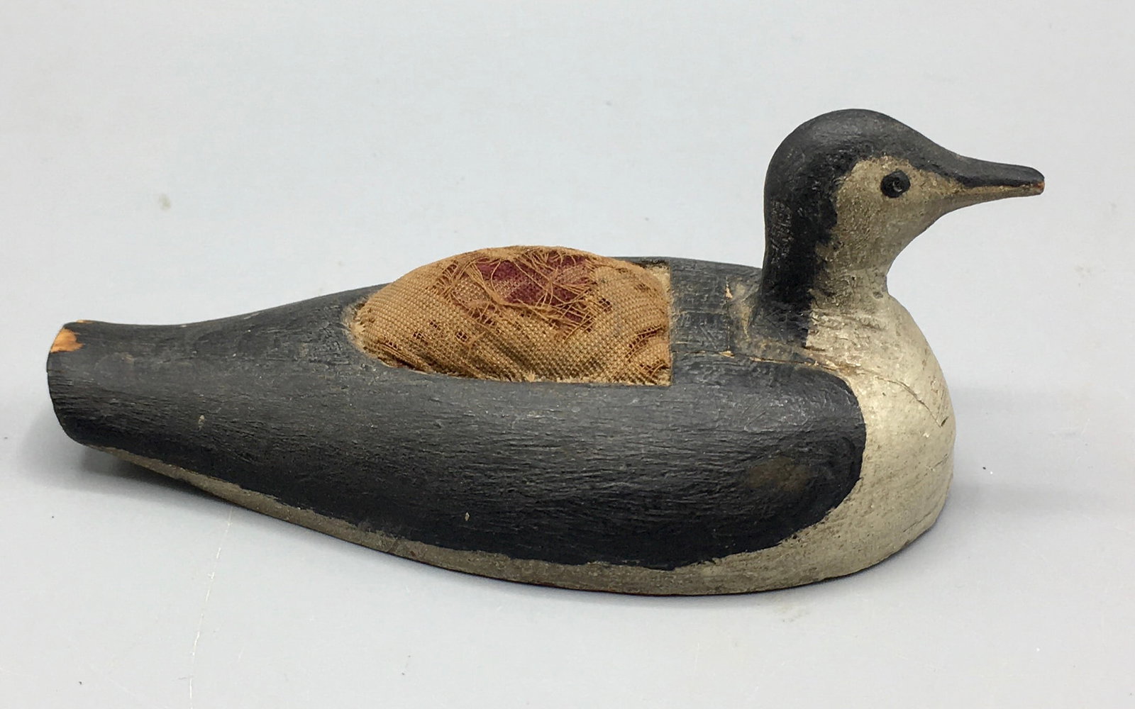 Miniature Loon Pincushion by Willie Eastman: A 5 inch miniature carved Loon with a pincushion in its back by Willie Eastman of Cundy's Harbor. Verbal history from Doc Starr stated this item was made by him for his wife. Original paint with wear 
