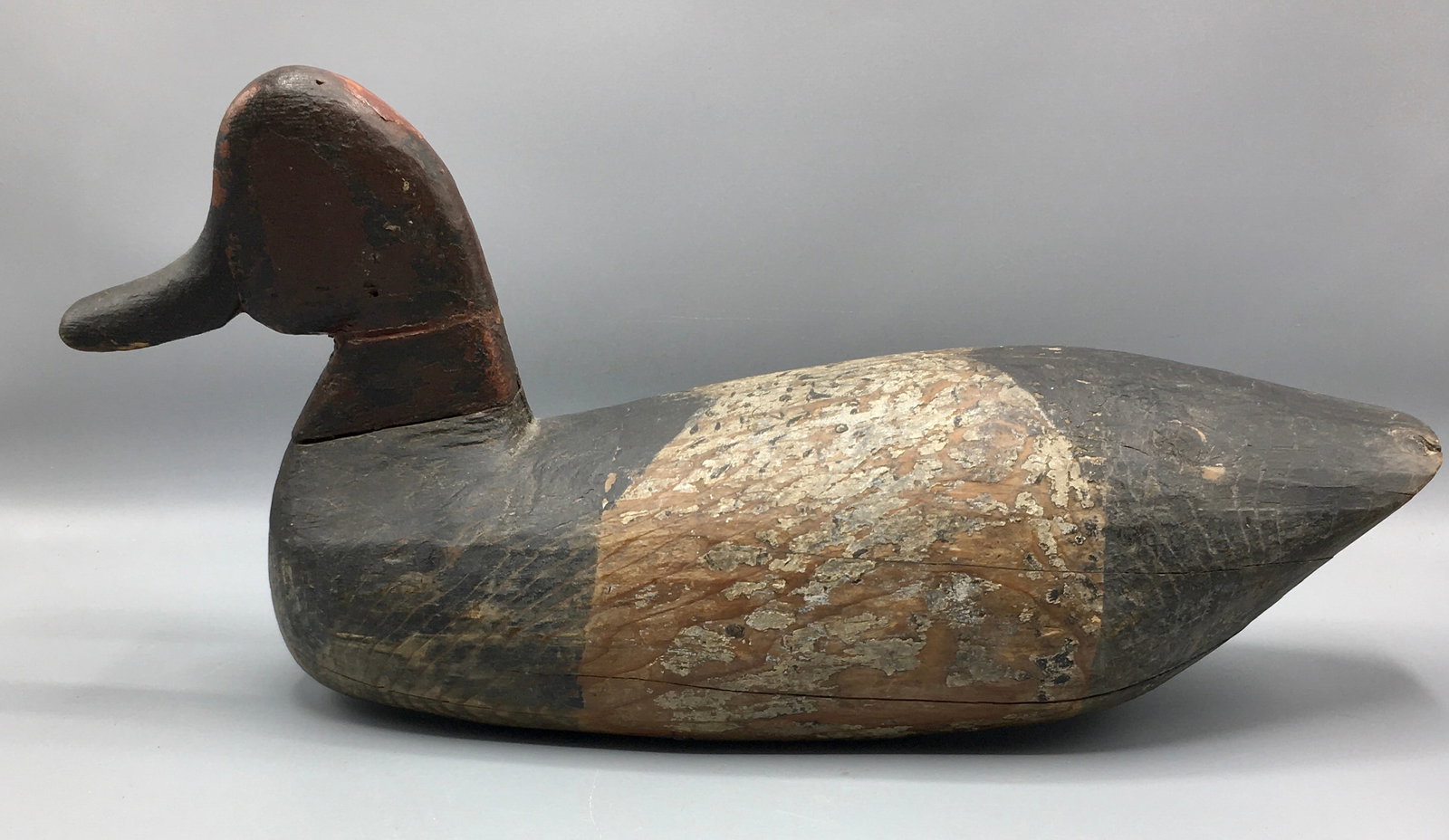 Early Red Head Drake: A 15 inch Red Head decoy, origin attributed to North Carolina. In old in-use paint with heavy wear and a neck repair.