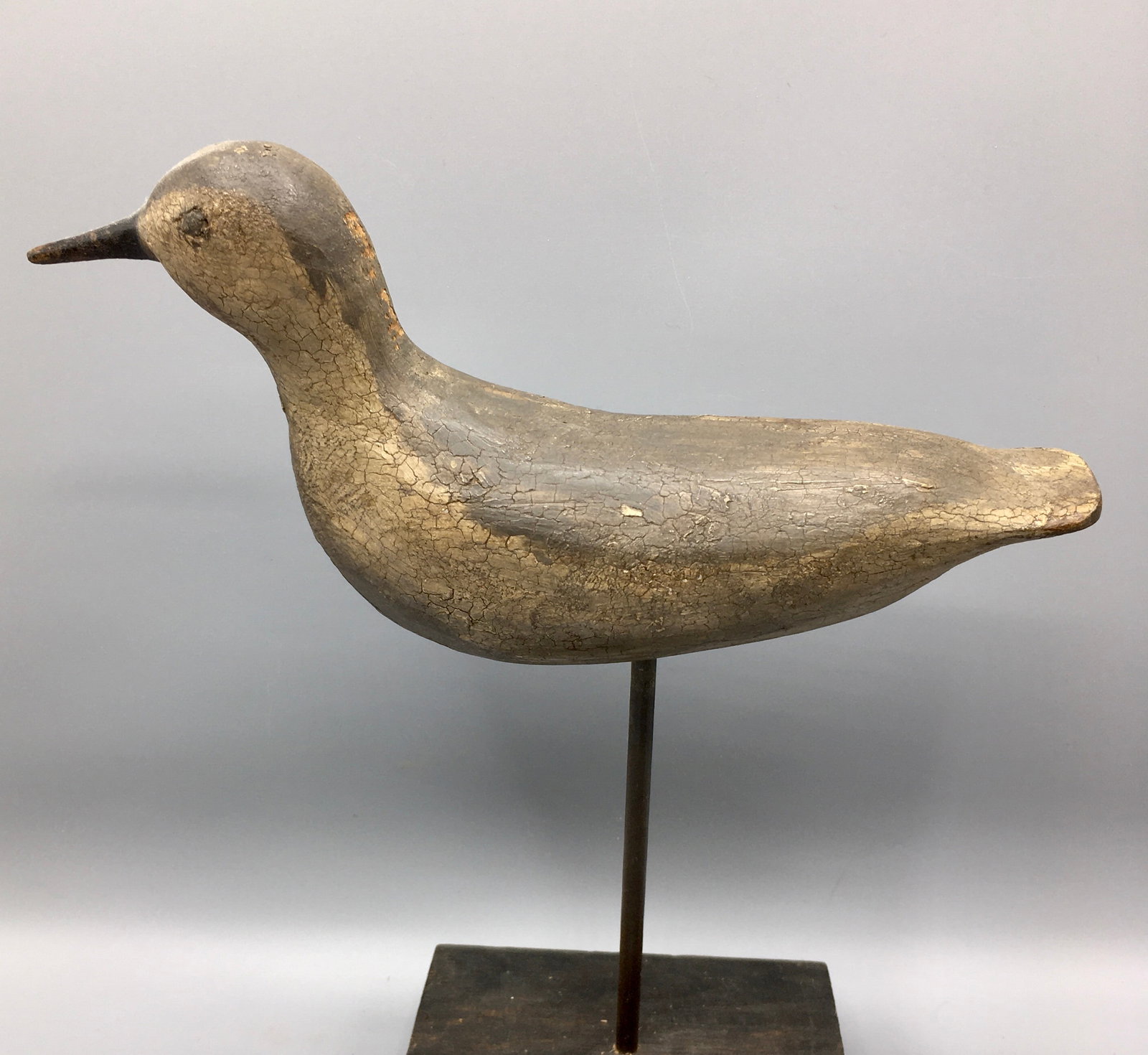 Running Shorebird Decoy: A 10 inch Shorebird decoy with carved eyes and raised primaries. In old paint with wear and extensive craquelure.