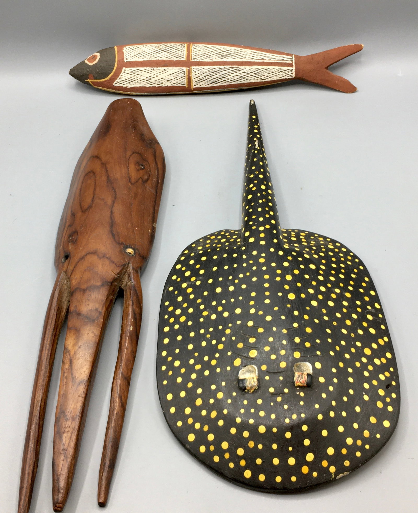 A Carved Fish, a Ray and a Squid.: Three carvings10 3/4 to 15 inch Squid, a well-painted Ray and a primitive Fish carving. Determine condition from the photographs.