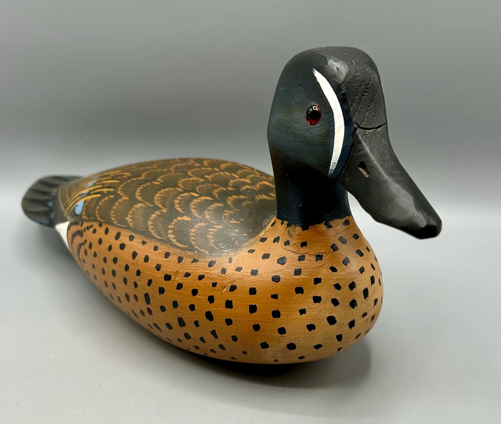 Blue-Winged Teal Drake by Lou Reineri: A hollow 13 inch Blue-winged Teal drake "hunting"decoy by Lou Reineri (1922-2019), Chincoteague, VA, signed and dated 2002 on the underside of the decoy. In original paint with expected wear for its a