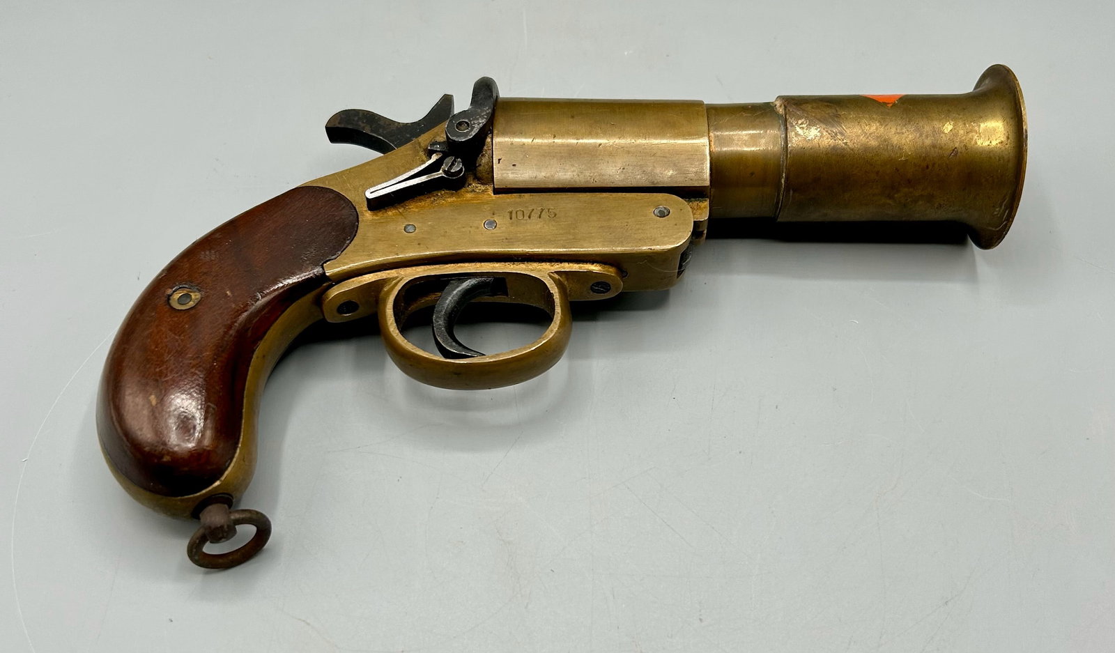 An Antique WWI Era British Brass Naval Flare Gun: A 9 1/4 inch World War One era British Brass Naval Flare Gun. Top of the barrel bears a partial maker's label, one side of the frame has a patent number and inspector's stamps. As found- with expected
