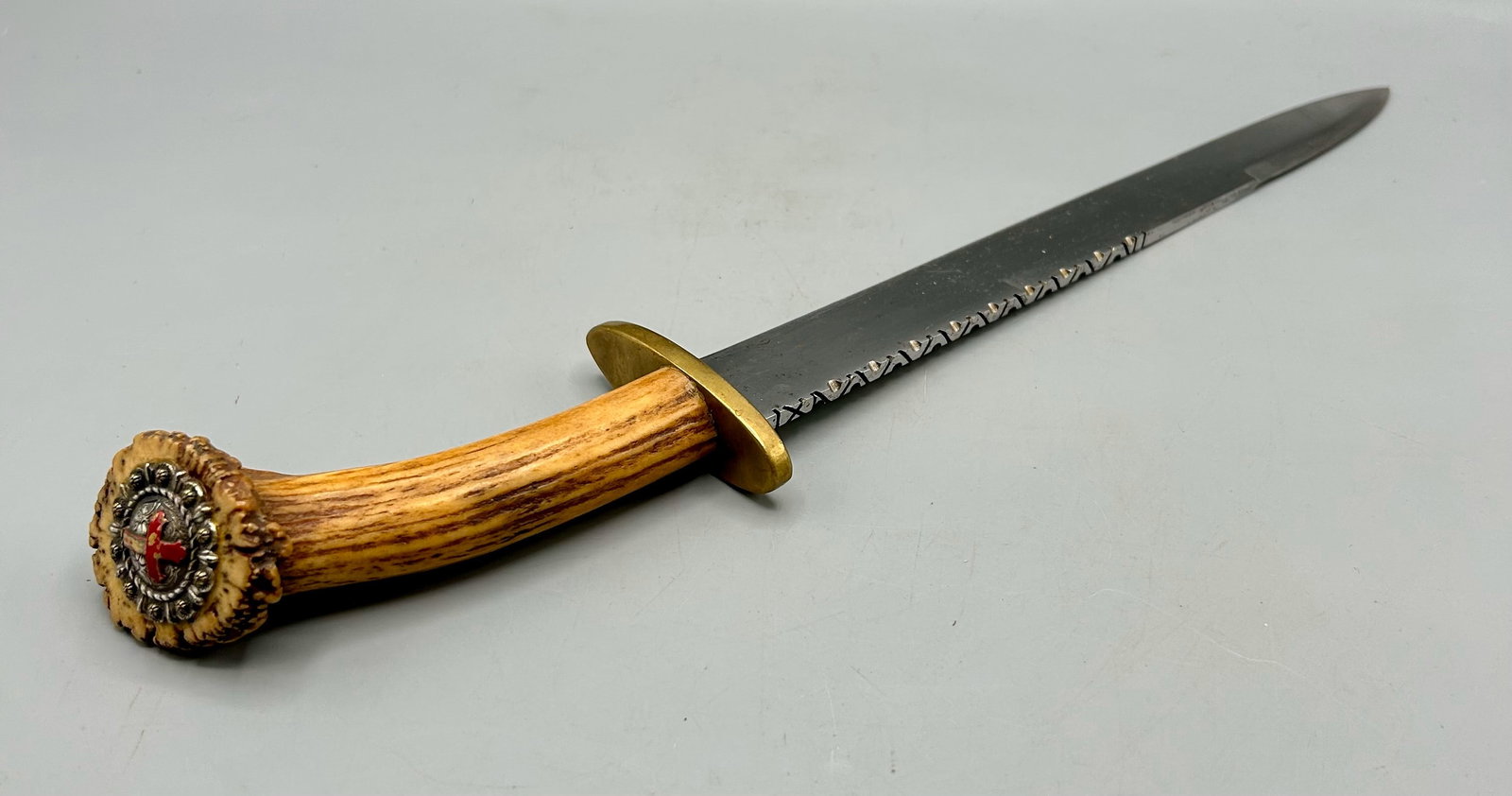 An Older Short Sword: A 17 inch short sword displaying a stag horn handle with a silver decorated butt cap with a repouse cross. As found- with expected wear for its age.