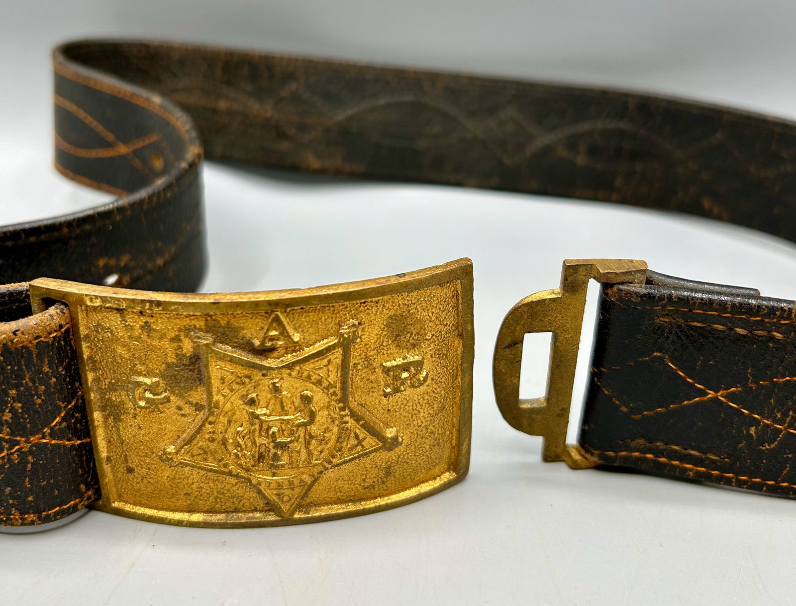 G A R Belt Buckle and a Period Leather Belt: A Grand Army of the Republic, Civil War veteran's belt buckle and a !9th century leather belt with decorative hand stitching. As found- with expected wear for its age.