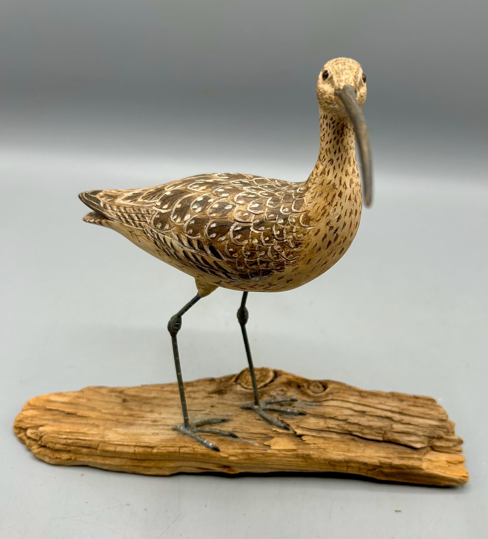 Miniature Long-Billed Curlew by Susan DeCoste: A 5 1/4 inch turned head carving, with the base 6 1/4 inches high by Susan DeCoste (b. 1959), Scituate, MA. Signed with the maker's initials on the bottom of the base with an etched outline of a shore