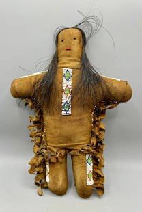 Native American Buckskin Doll: A 10 1/2 inch bead decorated buckskin and horsehair Native American doll with a paper label identifying the doll as an Apache tribal artifact. In good condition.