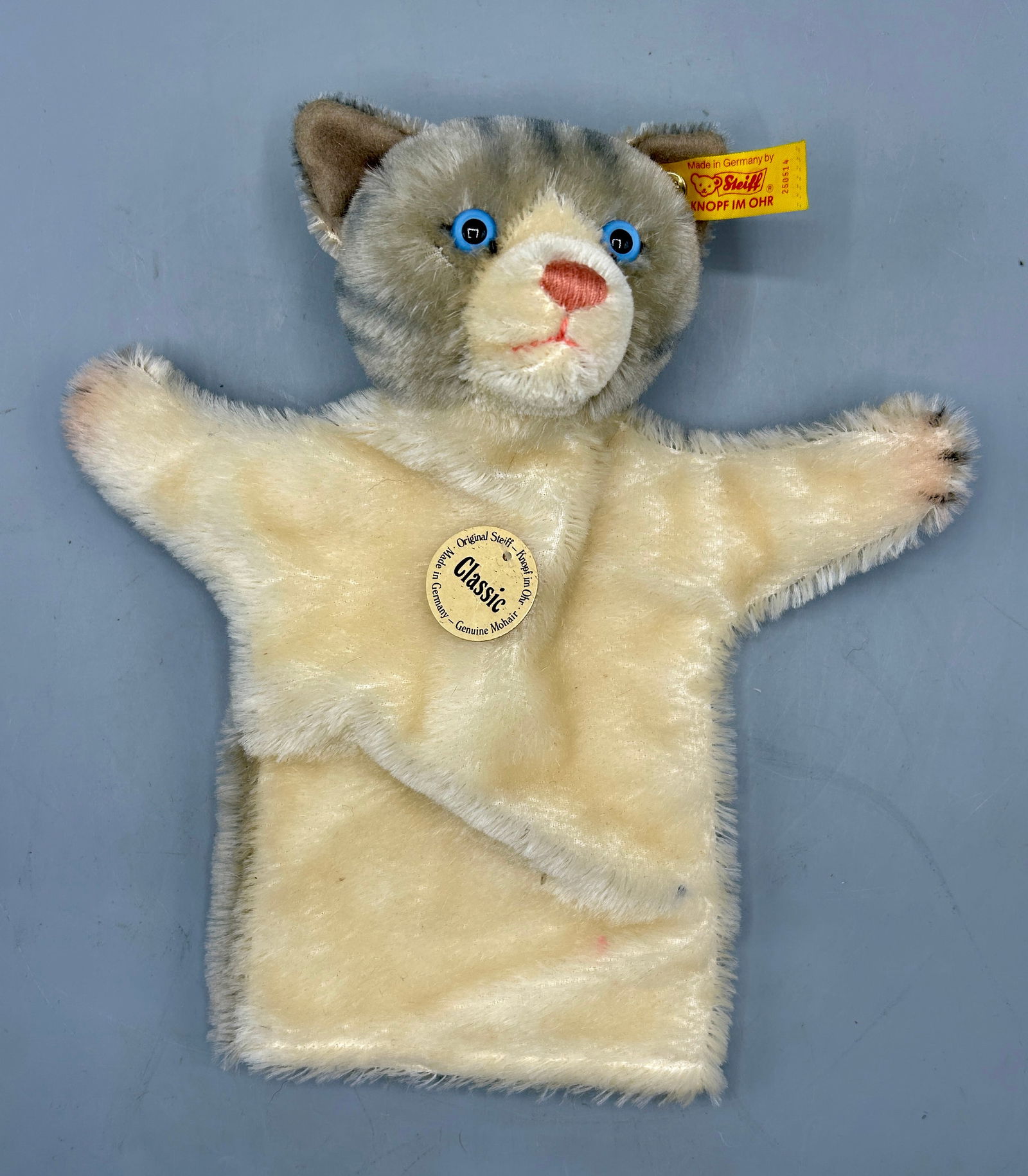 A Steiff Cat / Kitten Hand Puppet: A 10 1/2 inch mohair kitten puppet by Steiff from Germany, with its original paper tag and ear button. In original condition with minimal wear.