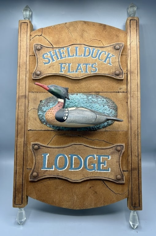 Miniature Merganser Decoy on a Lodge Sign: A 9 inch miniature full-bodied Red-breasted Merganser decoy attr. to Lou Reineri (1922-2019) from Chincoteague, VA The 23 by 13 1/2 inch sign board has individual plaques that read Shellduck Flats, Lo