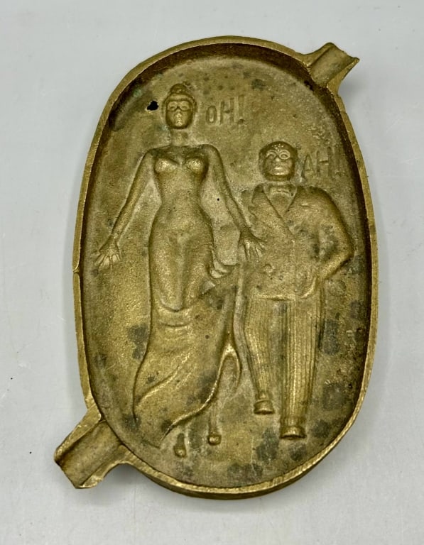 Antique Two-Sided Naughty Bronze Ash Tray: A 5 1/2 by 3 1/2 inch entitled "Oh! Ah! " circa 1900 to 1920. The motif depicts a tall formally dressed woman and a shorter stockier well-dressed man. The reverse depicts naughty contact between the t