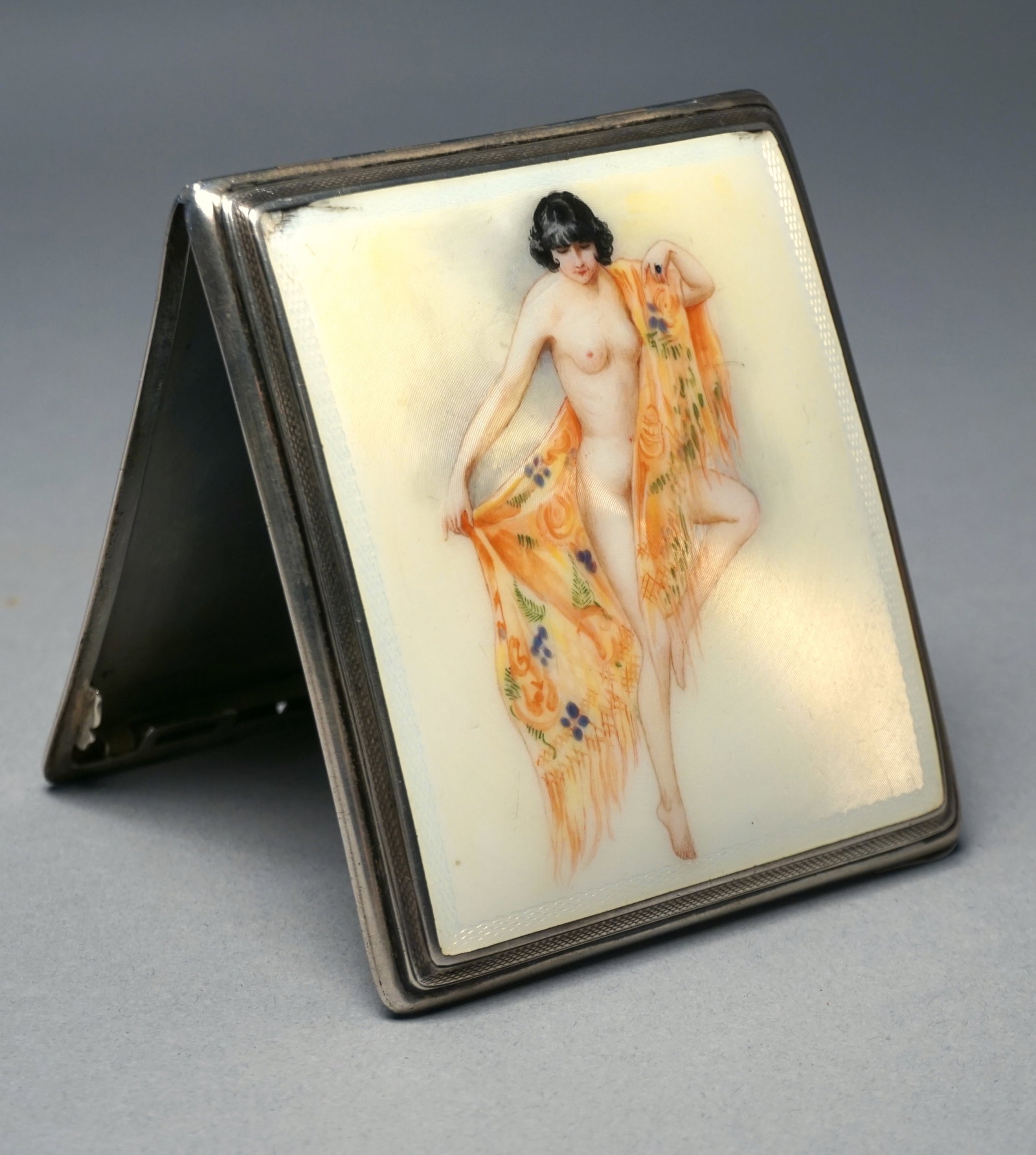 1920s Deco enamel cigarette case flapper girl, sterling silver: Antique enamel cigarette case 1920s erotic flapper girl on enamel wrapped in shawl. Hallmarked sterling silver. One stamp of .950 and one written out Sterling stamp inside of case. Measures 3" wide x 