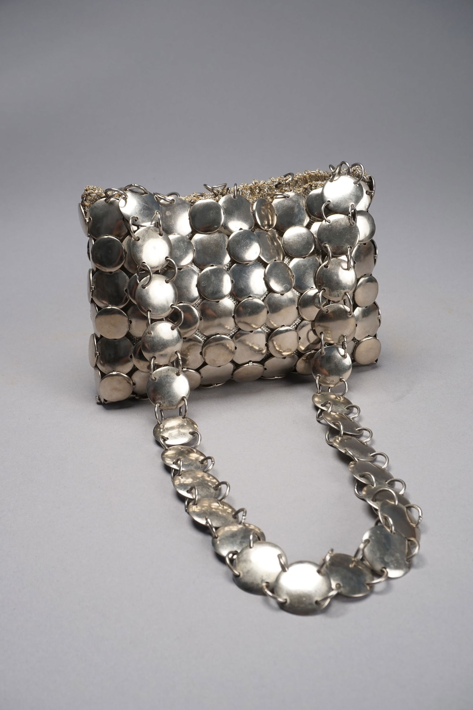 Rare vintage silver disc purse manner Paco Rabanne, Bloomingdales Italy: Vintage 1960s made in Italy Bloomingdales silver metal disc purse. Woven silver interior. Measures 7" wide x 5" long x 18" long including strap.