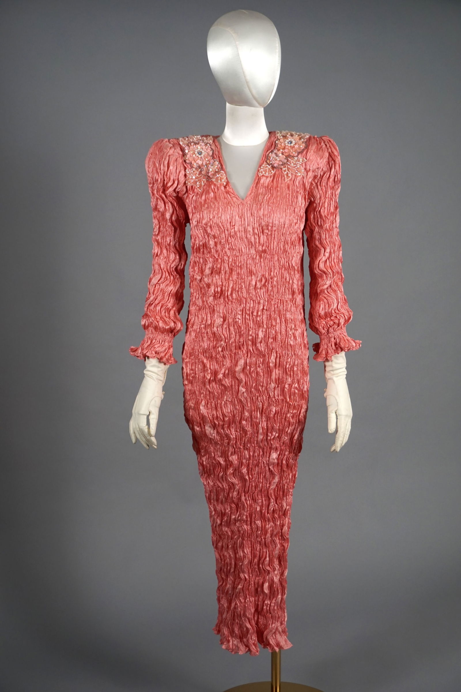 Vintage Pink Fortuny Plisse Pleats Embroidered Dress: Vintage 1980s pink fortuny pleat full length long sleeve dress with glass and plastic sequinned embroidered bodice. Padded/ puff shoulders. Ties at the back. Fluid in size and slips on over the head.