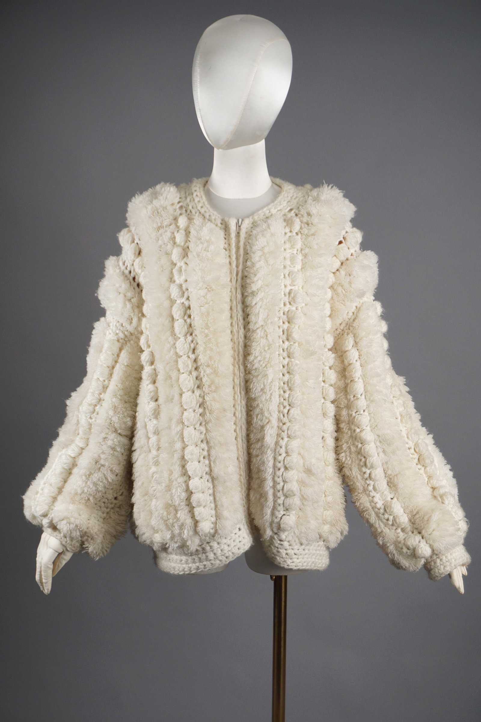 le Chois Vintage Ivory Puff Sleeve Sweater with Bobble Knit Design: This charming vintage sweater by le Chois features an intricate bobble knit design in a soft ivory hue. It showcases rows of raised bobble detailing framed by textured cable-like patterns, creating a 