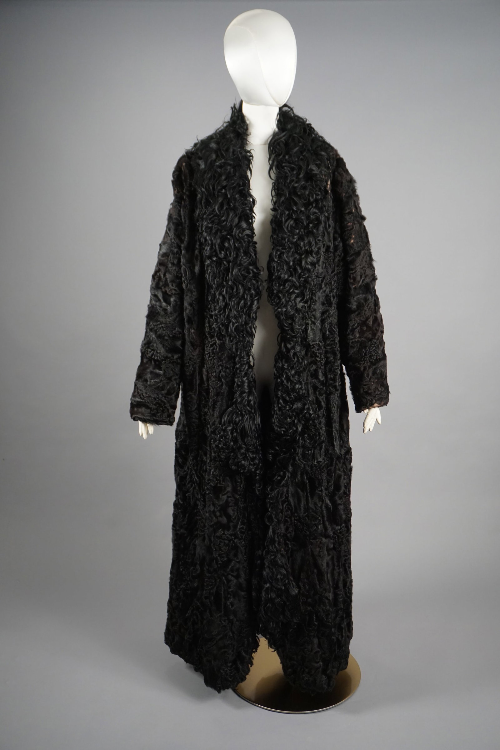 Edwardian Black Persian Lamb and Curly Astrakhan Fur Coat: This elegant Antique Edwardian full-length fur coat features sumptuous black Persian lamb fur with a wide, dramatic collar of curly Astrakhan fur. The coat’s flowing silhouette and full-length sleev