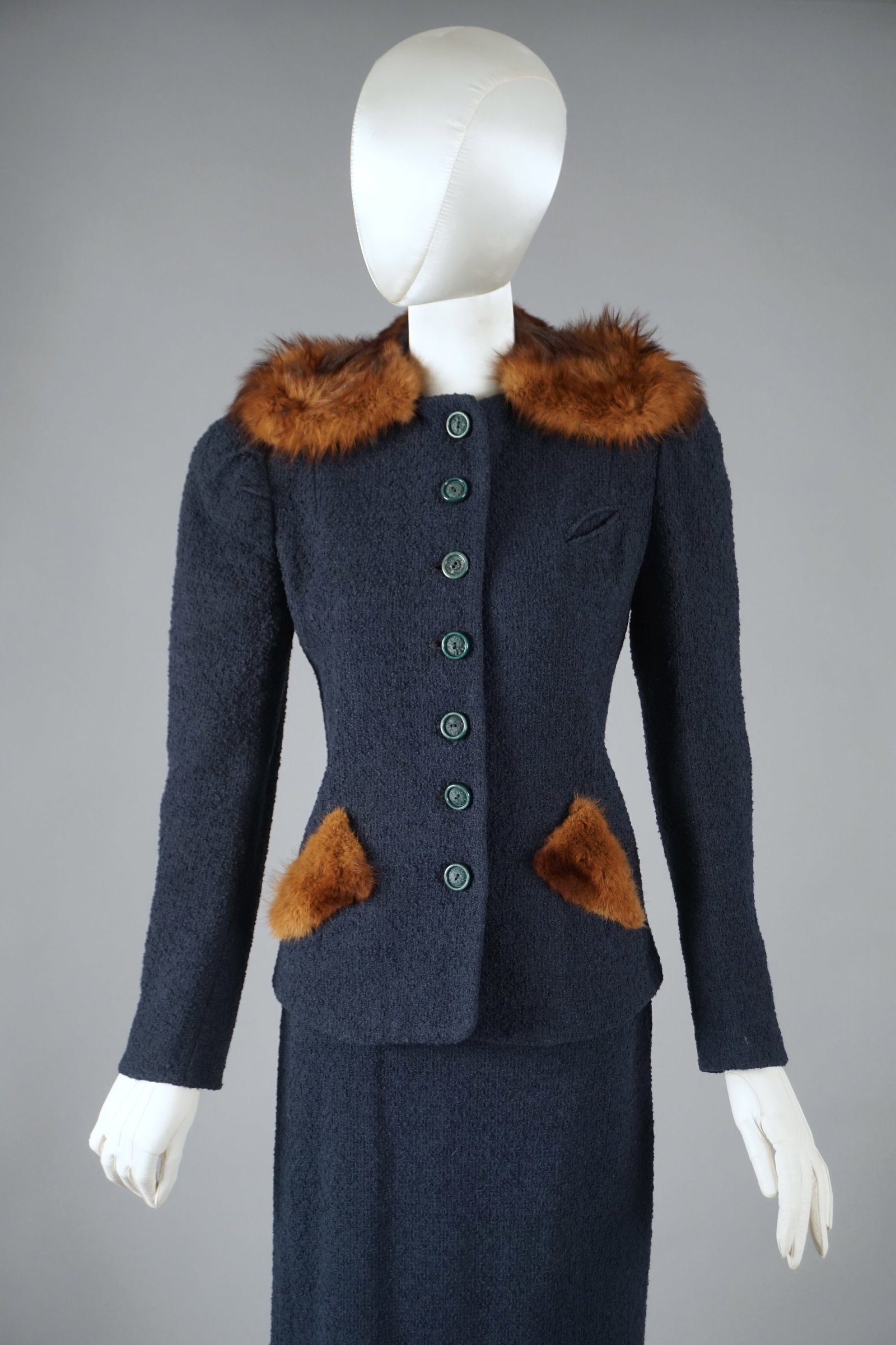 Vintage 1940s Boucle Wool Fur Skirt Suit by Townley: A classic 1940s navy skirt suit by Townley, retailed at Volk’s Dallas. The jacket is tailored in a textured boucle wool and features a rich real fur collar and matching fur-trimmed pockets. Eight se