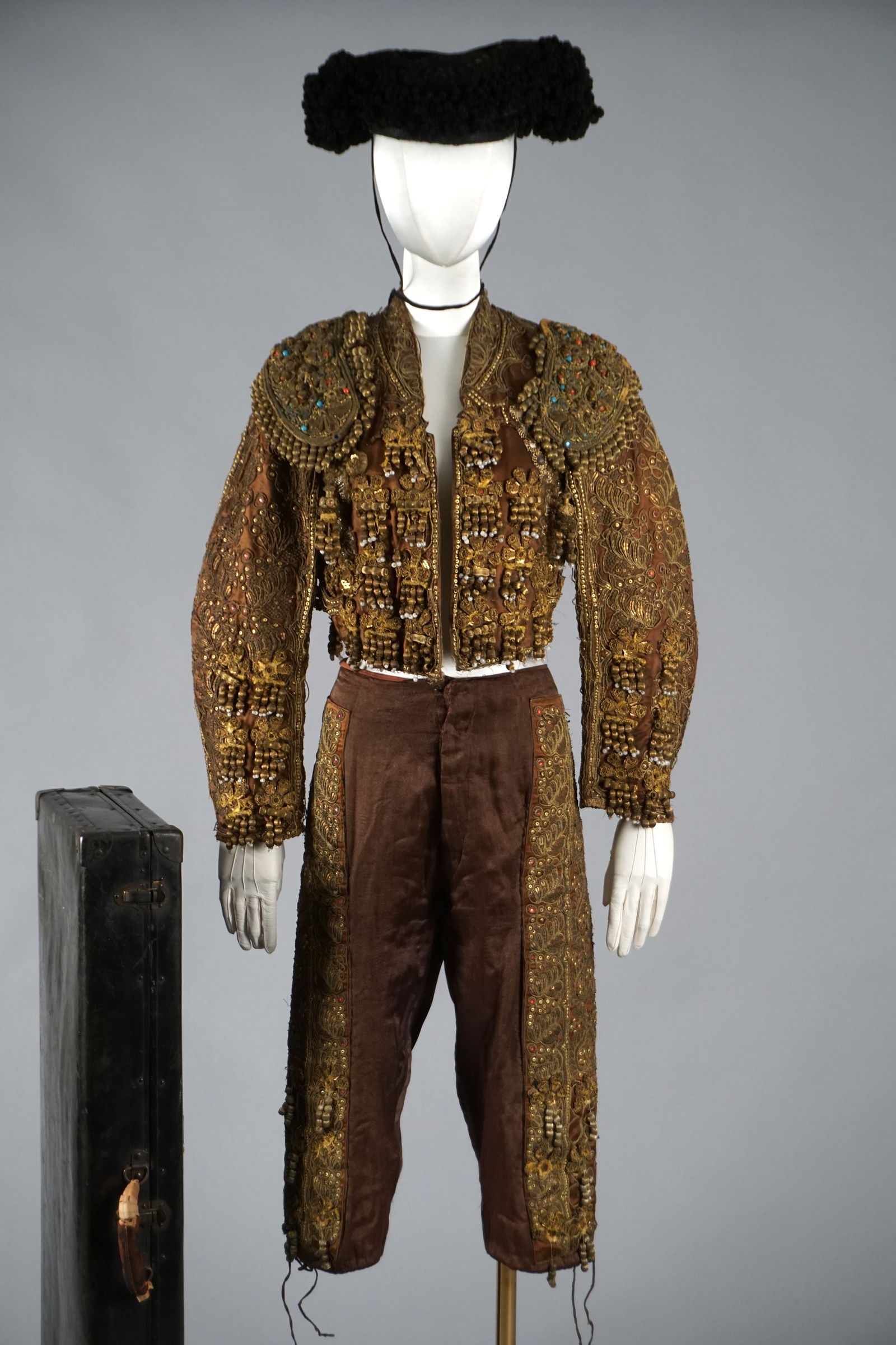 Antique Metal Embroidered Spanish Matador Suit Dress Ensemble, Original Travel Case, José Uriarte,: An extraordinary and rare complete Spanish traje de luces (“suit of lights”) dating to the late 19th century, comprised of its original montera (hat), chaquetilla (bolero jacket), and high-wai