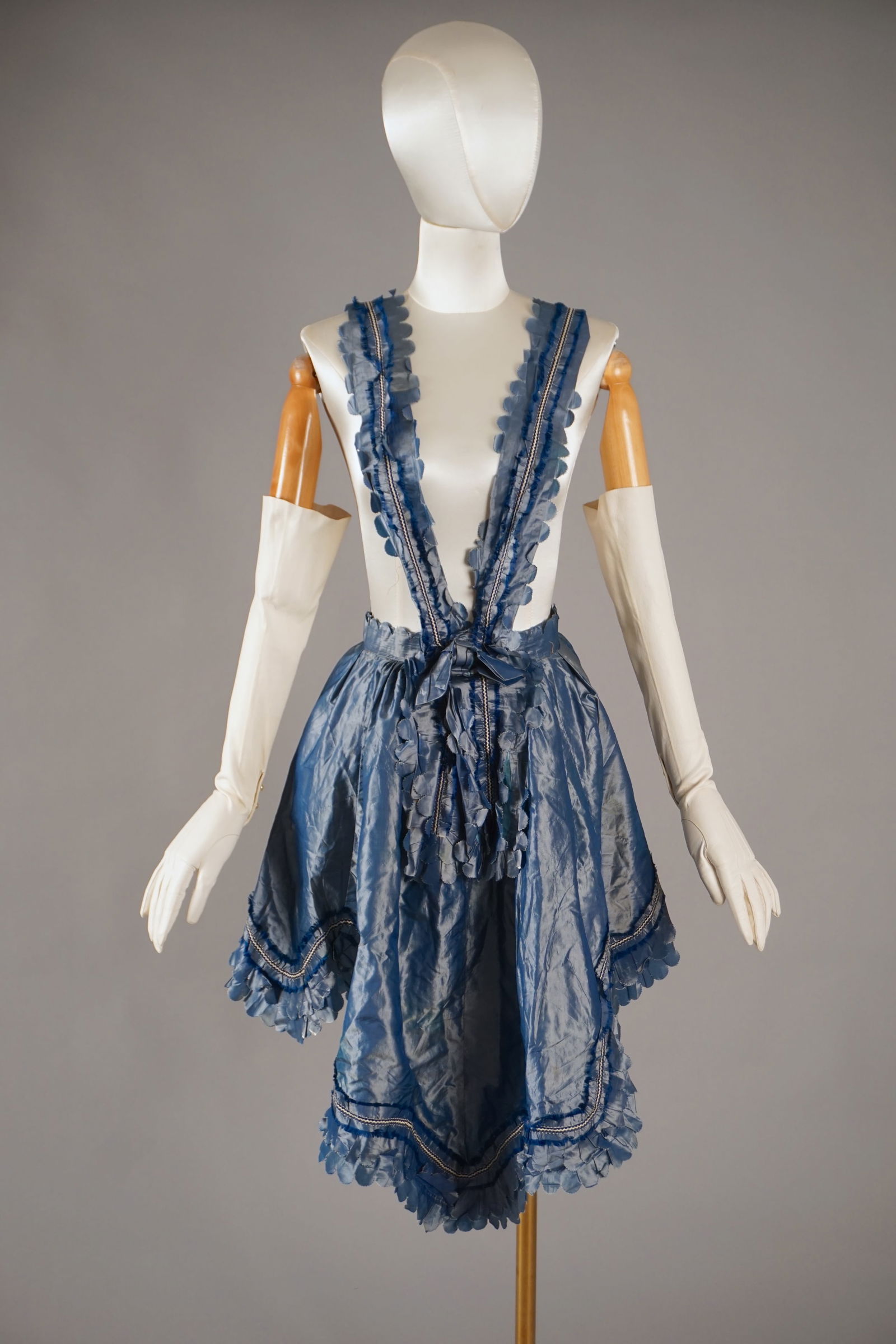Civil War Era Blue Silk Apron with Scalloped Leaf Trim, c.1860s Dress: A beautifully preserved mid-19th century apron/skirt crafted from shimmering blue silk taffeta. The apron is edged with a wide border of scalloped and pleated silk trim, forming stylized leaf-like mot