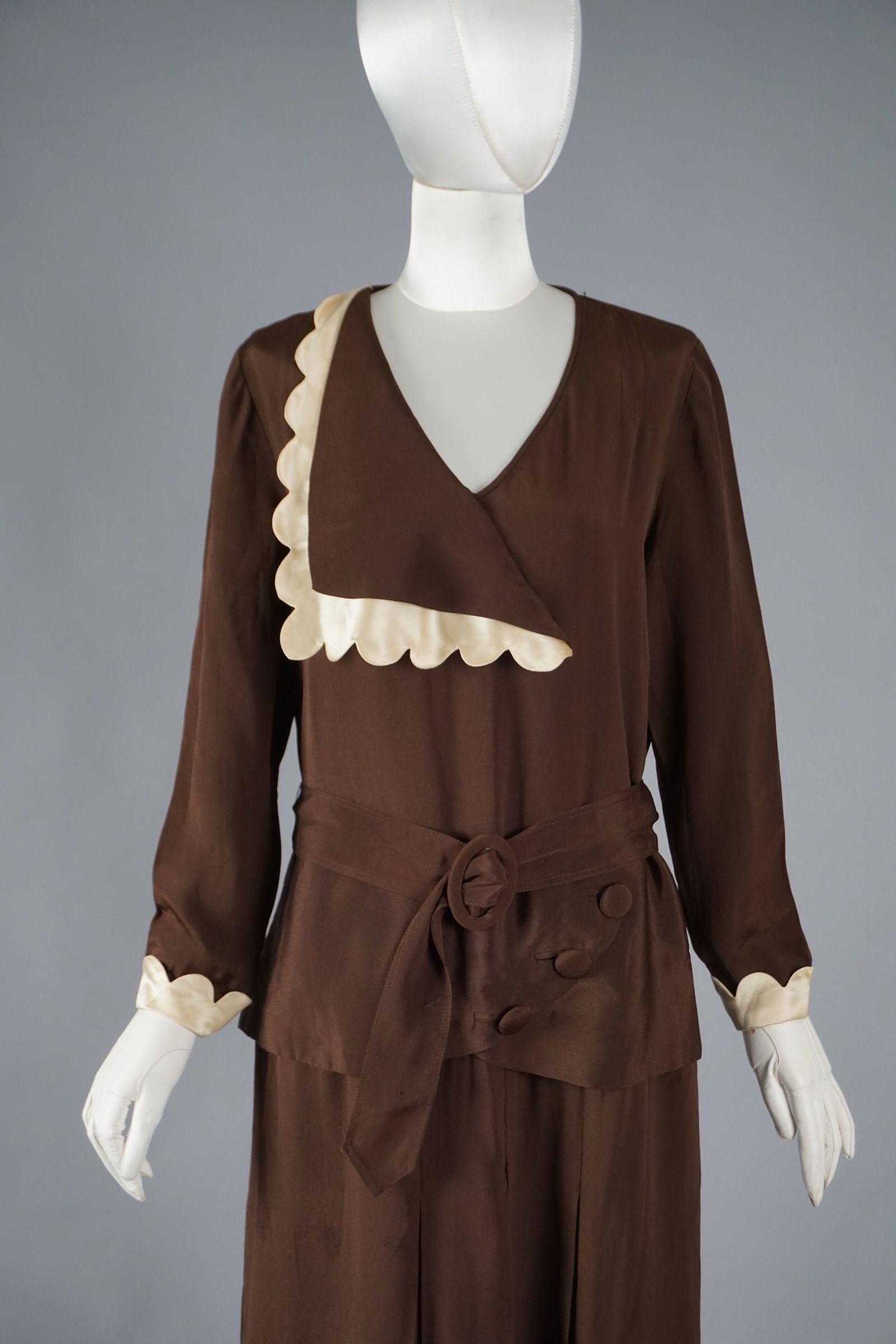 Vintage 1920s Brown Crepe Dress with Scalloped Silk Satin Trim: Antique 1920s day dress in rich chocolate brown crepe, featuring cream silk satin scalloped trim at the collar and cuffs. An asymmetrical collar and with the original matching belt with rosette-style