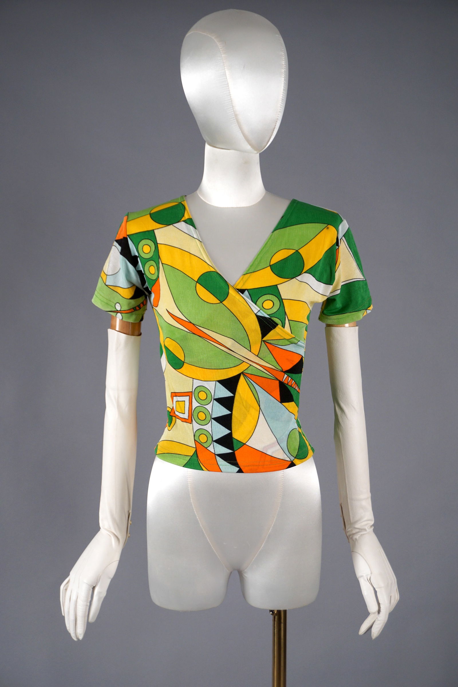 Vintage Psychedelic Wrap Top in the Style of Emilio Pucci, Late 20th Century: Vintage Lycra wrap top channels the unmistakable influence of Emilio Pucci. Likely from the 1980s or 1990s, the design features a vivid allover print in citrus greens, orange, yellow, and black—rend