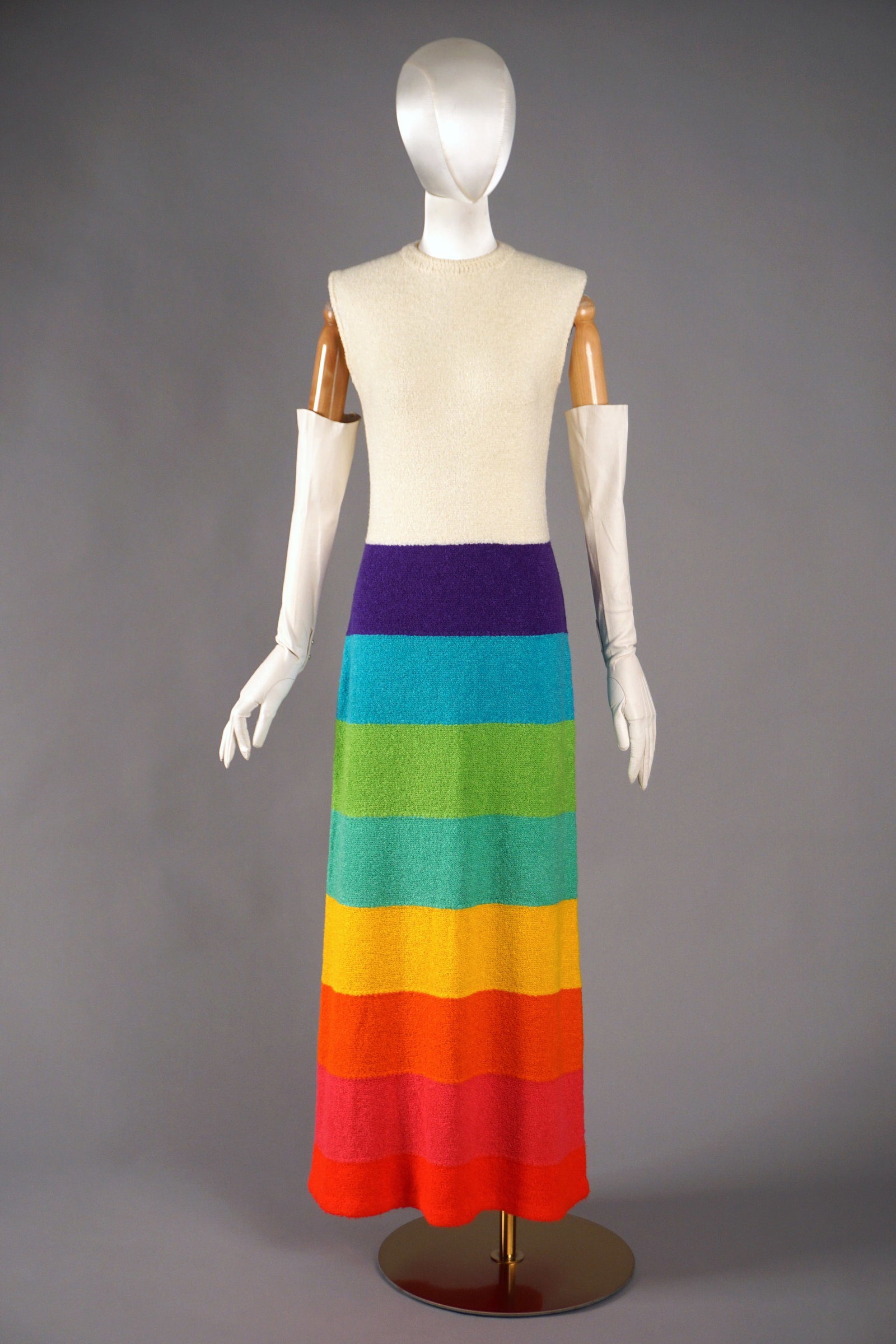 Vintage 1970s St. John Knits Rainbow Dress Striped Bouclé Maxi: A rare and exuberant piece from St. John Knits from the early 1970s, this vintage sleeveless maxi dress is knit in the brand’s signature textured bouclé yarn. Featuring bold horizontal rainbow stri