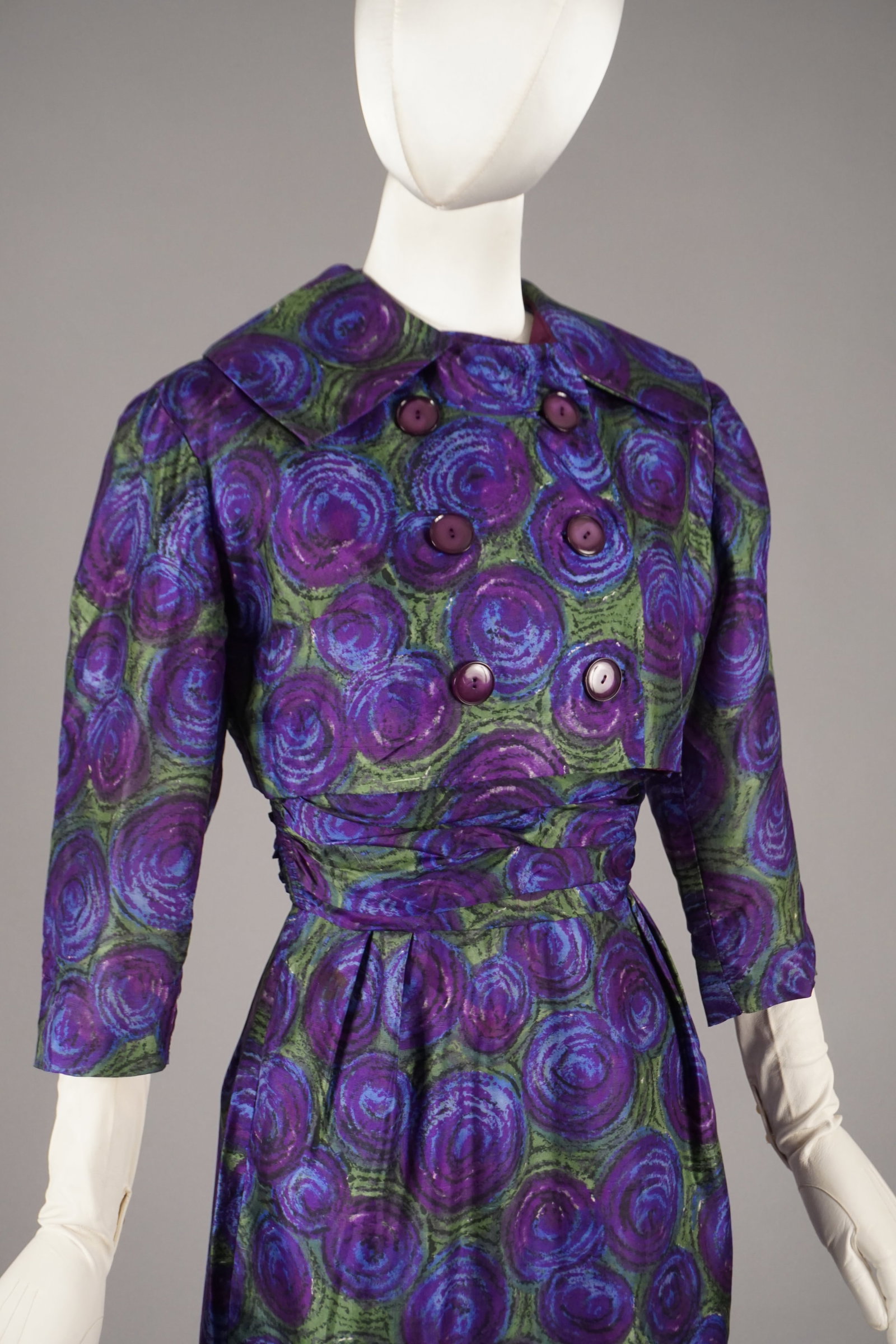 Vintage 1950s Two-Piece Dress & Cropped Jacket, Purple Green Rose Print: A mid-century ensemble from New York label Harry S. Epstein, featuring a sculptural 2-piece silhouette in a vivid abstract rose print. The sleeveless belted dress is paired with a matching cropped dou