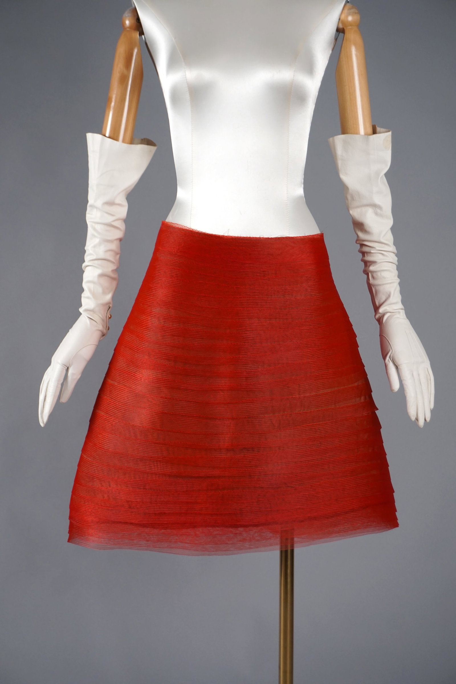 Unusual Vintage Sculptural Skirt in Iridescent Red Mesh: A striking skirt crafted from tiered sheer red mesh with a luminous, sculptural quality. The exterior features delicately layered horizontal bands that create a dynamic, wave-like texture with a subtl