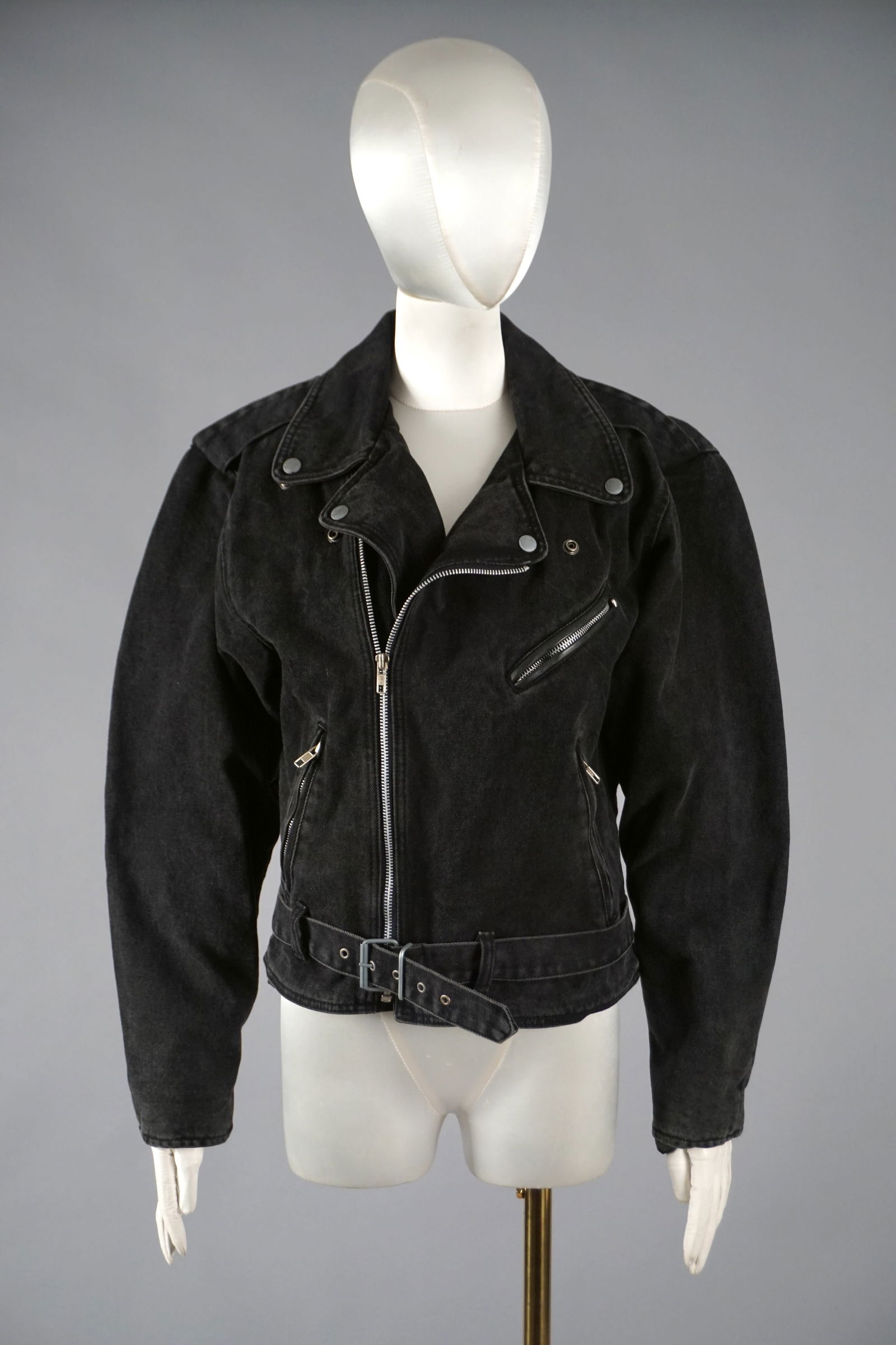 Harley Davidson Black Denim Moto Jacket, “An American Legend: Harley-Davidson moto jacket features a heavy black denim body with silver-tone hardware, angled zip closure, notched lapels, and belted waist. The chest is with snap epaulettes, while the interior pro