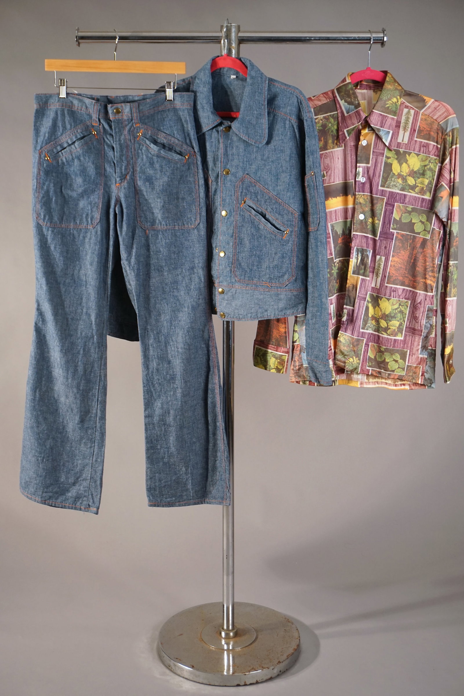 Vintage Men’s 1970s Denim Jacket Pants Set & Print Shirt: Vintage menswear lot includes a 1970s light-wash denim set with matching jacket and flared trousers, featuring angular pocketwork, orange contrast stitching, and brass snap buttons. Likely made for th