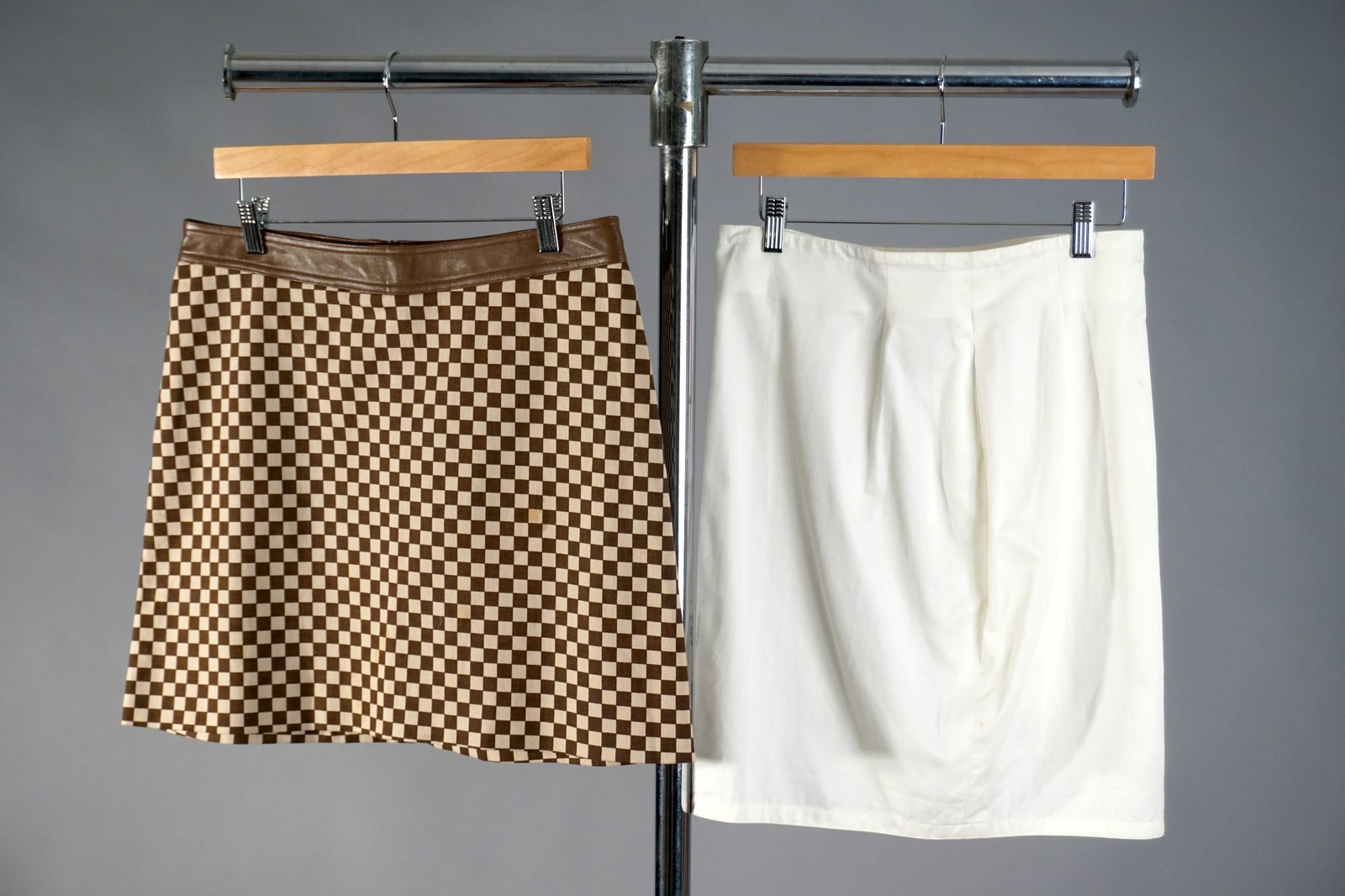 Lot of Two Designer Skirts, Gianni Versace & A.B.S. by Allen Schwartz: Two designer skirts. The first, by Gianni Versace, is a minimalist ivory cotton skirt with subtle darting and Italian tailoring, labeled size 42. The second is a bold checkered mini skirt by A.B.S. by