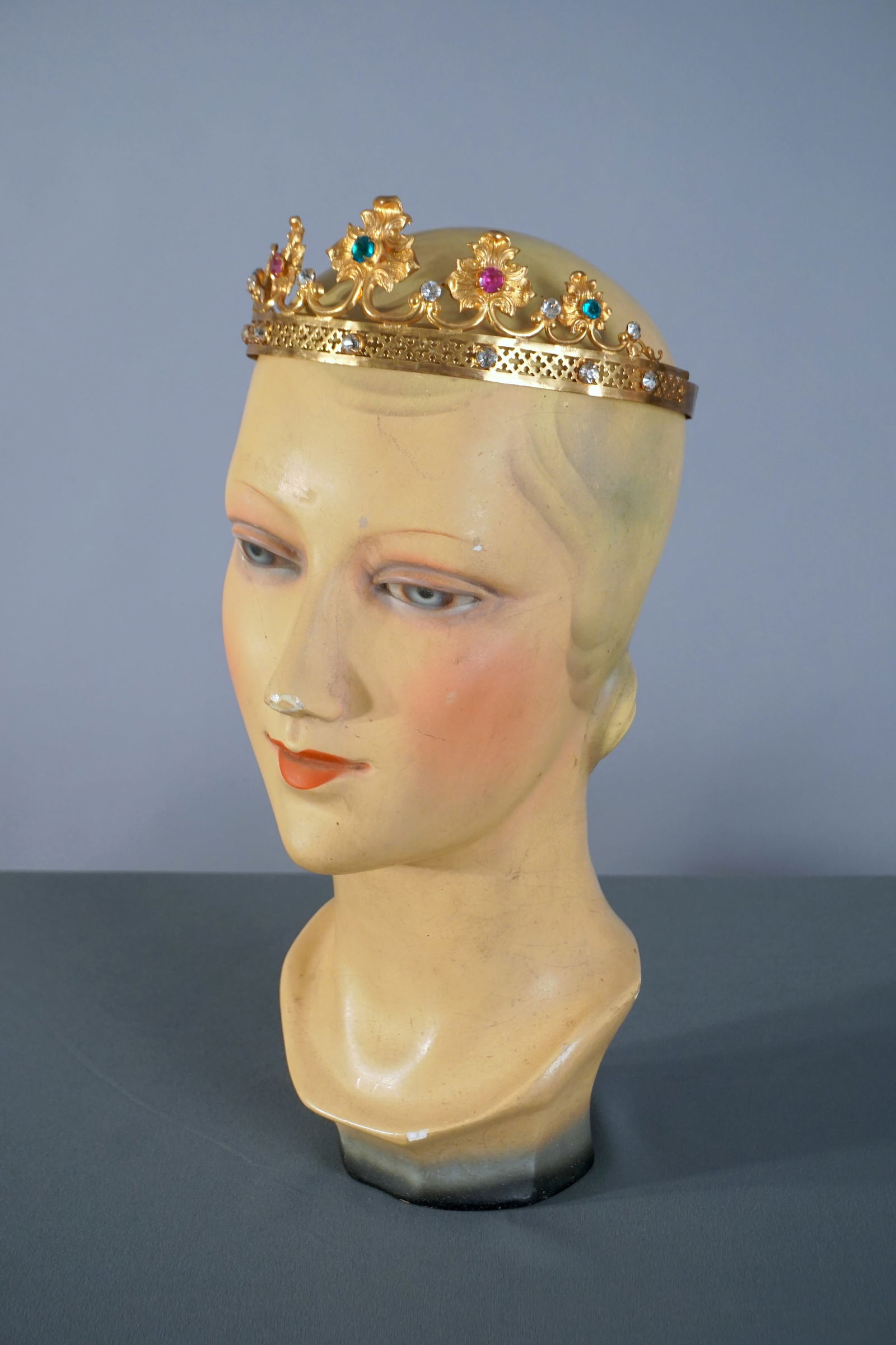 Antique Gold Filigree Tiara Theatrical Crown with Jewels: A gilt metal theatrical stage crown tiara circa 1900 with foliate repousse detailing and inset colored stones in blue, red, and clear tones. The pierced base band features quatrefoil cutouts and appli