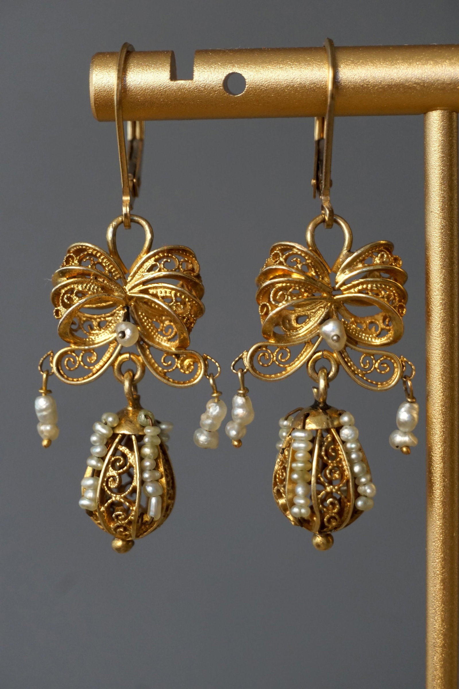 Antique Gold Filled Bow Earrings with Seed Pearls: Elegant antique pair of yellow gold filled/plate earrings, designed as a filigree bow suspending a delicate drop. The drops are finely worked with scrolling gold wire and adorned with genuine seed pea