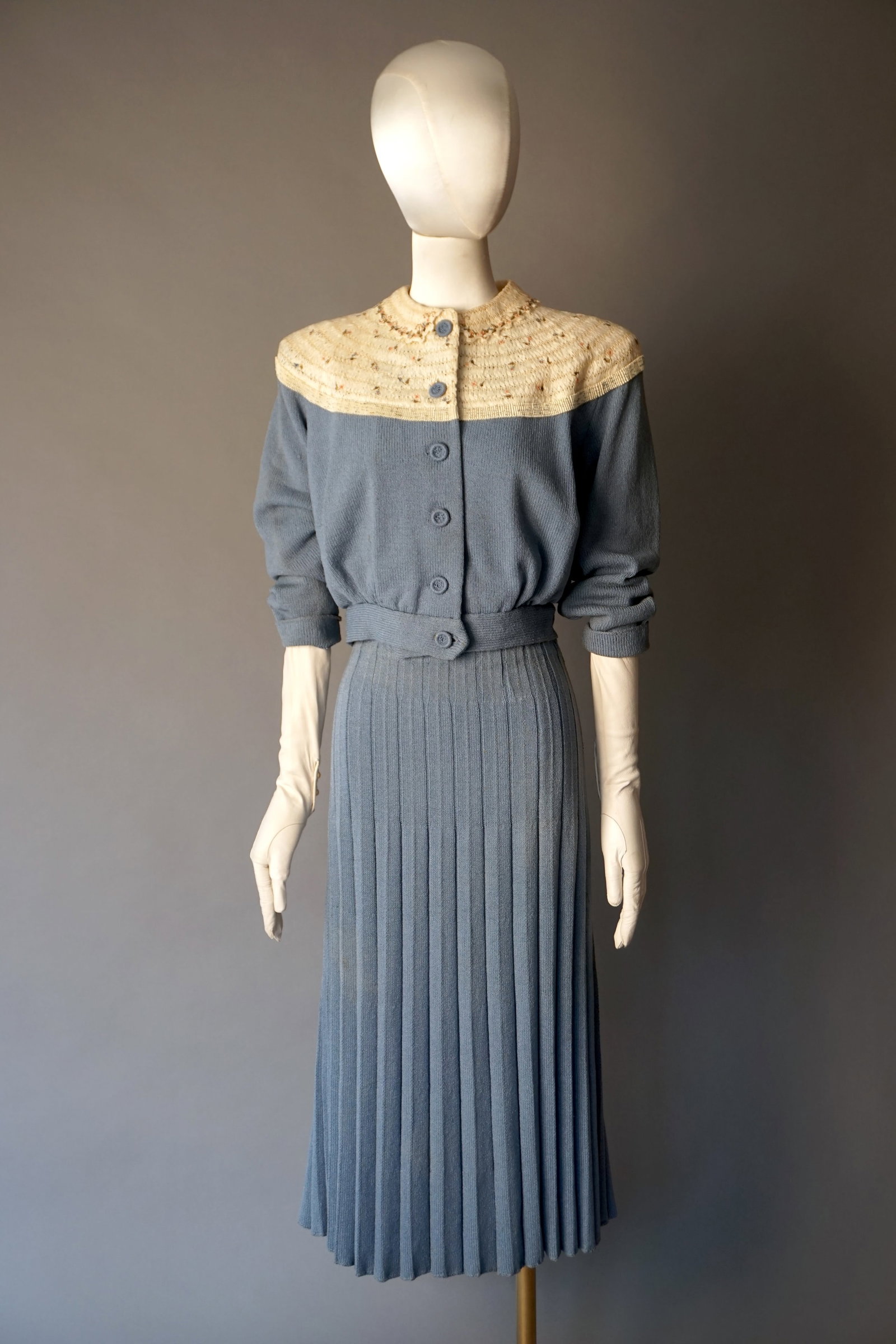 Vintage 1950s Margot Reiss Hand Knit Originals Blue Skirt Suit: 1950s Powder blue knit skirt suit by Margot Reiss Hand Knit Originals, known for high quality hand knit European imports. The top features a cream yoke intricately smocked with pastel floral embroider