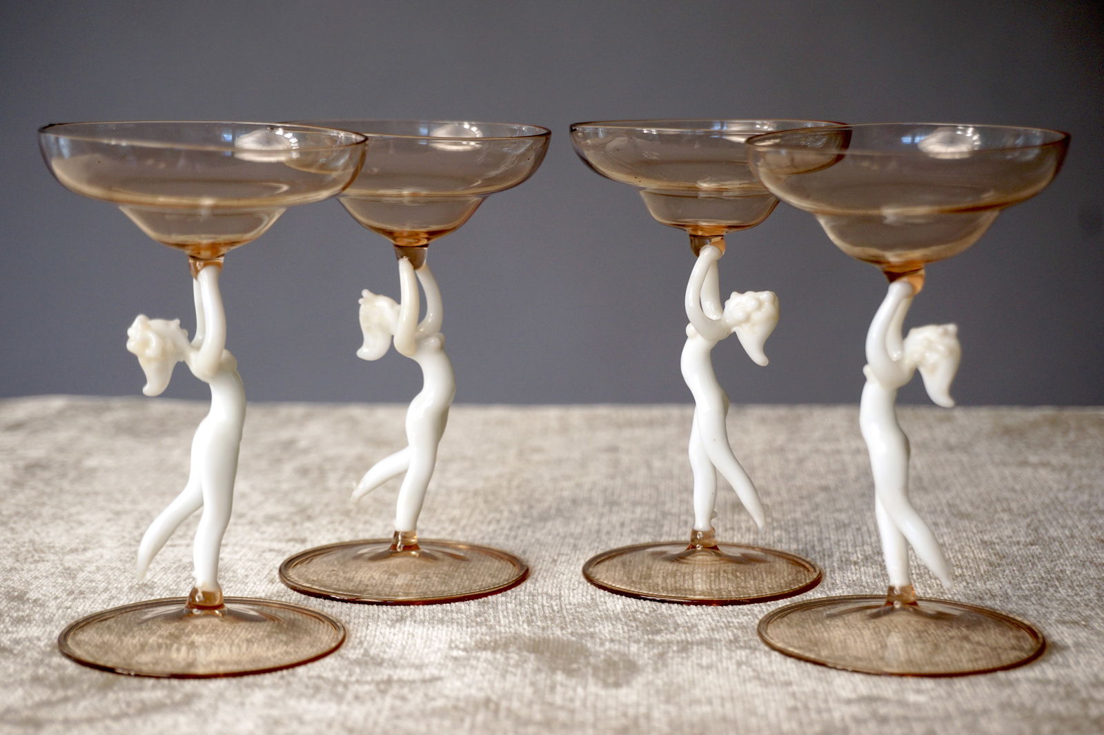 Four 1920s 30s Bimini Austrian Pink Nude Stem Cordial Glasses: A set of four figural stem glasses by Bimini Glas, Vienna, dating to the late 1920s–30s Art Deco era. Each features a pale pink amber coupe bowl supported by a hand lampworked opaline nude female fi