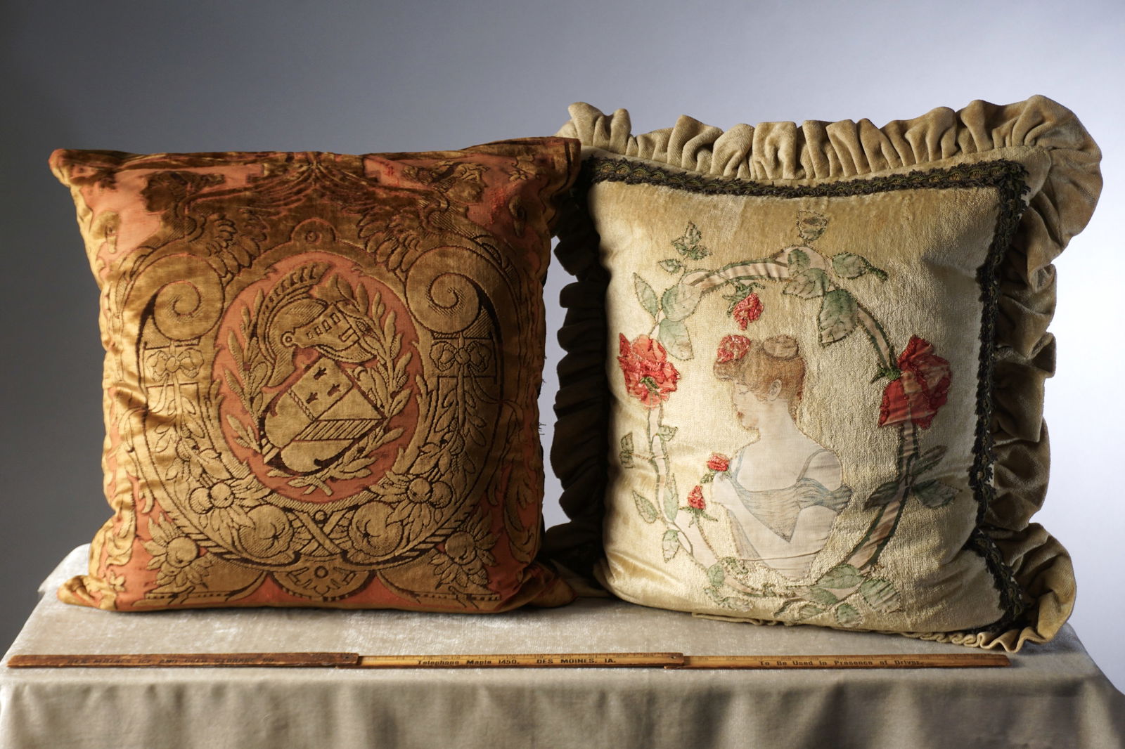 Pair of Vintage French Handmade Pillows with Appliqué Portrait and Heraldic Velvet Design: A pair of custom made vintage French pillows- one features a soft velvet ground in pale sage with an appliqué and embroidered portrait of a young woman in profile. Her hair is styled in an Edwardian