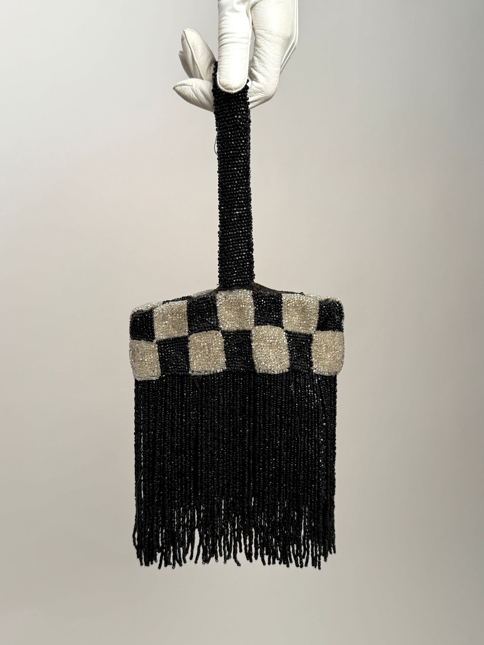 Antique 1920s Glass Beaded Flapper Purse, Black & White Checkerboard: Vintage 1920s flapper handbag richly decorated with hand applied glass beads in a black and white checkerboard motif, finished with long black beaded fringe and a matching beaded strap handle. 6" x