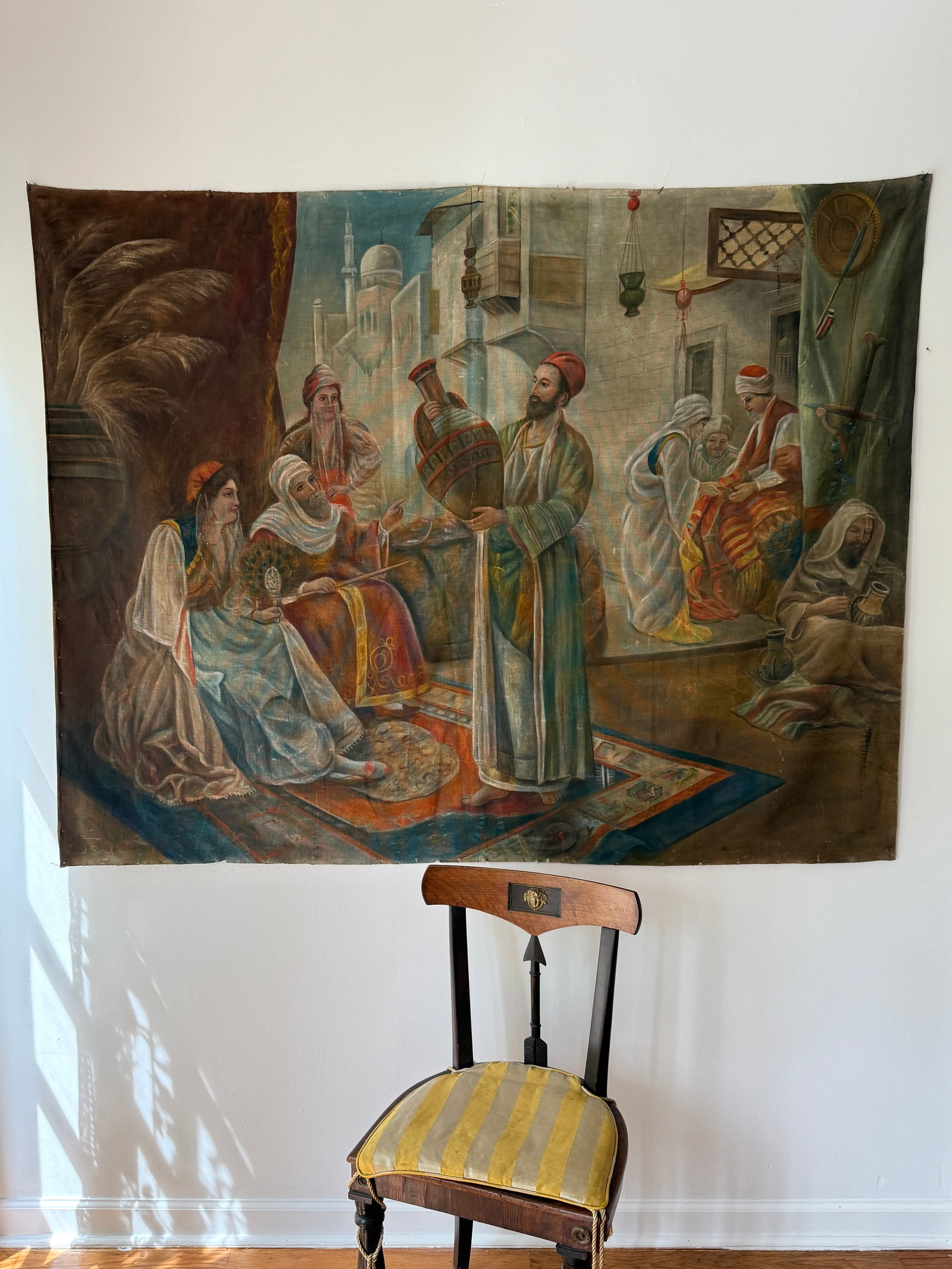 19th C. Orientalist Painting on Canvas Wall Hanging Backdrop, "Market Scene with Ceramic Merchant": Dating to the late 19th C.- 1900s, this large scale 50" x 63.5" painting on canvas depicts a vibrant Orientalist marketplace scene based on the T. E. Cowen Orientalist Market Scene. The work is execut
